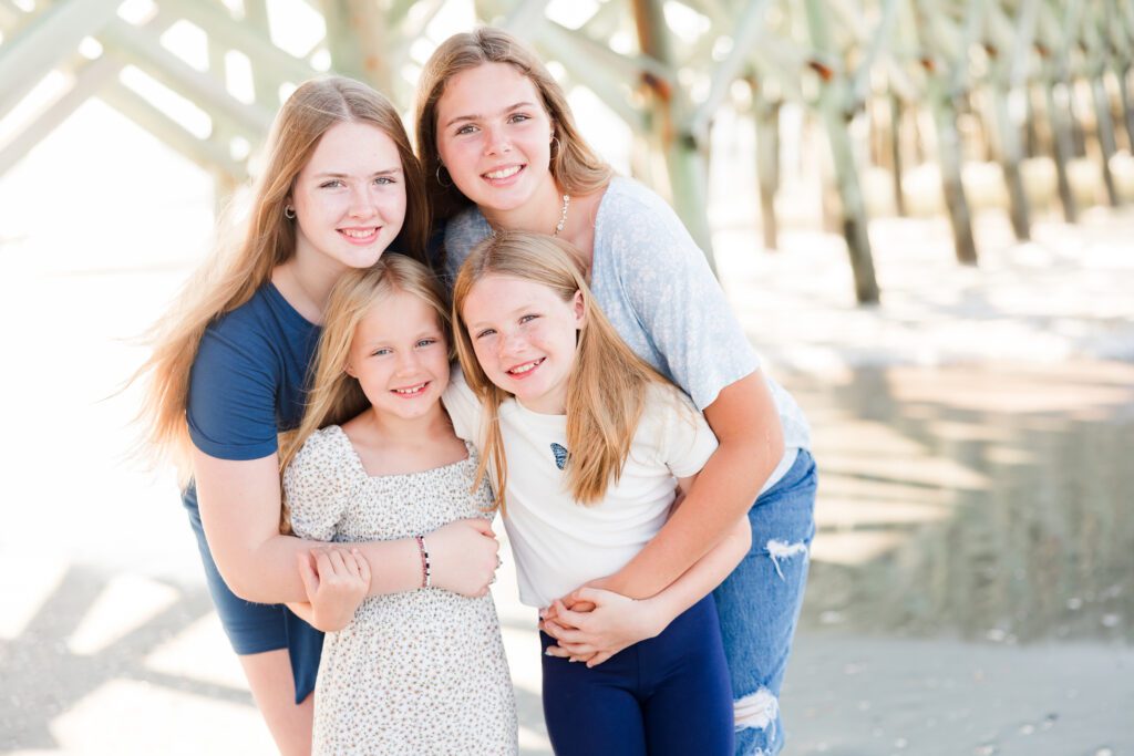 four sisters posing on beach for photos