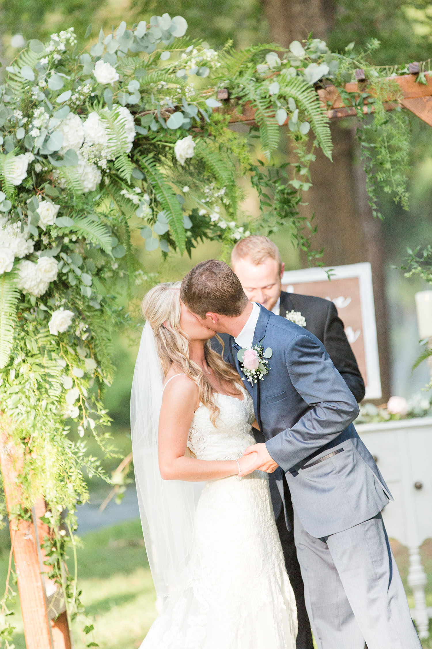 Bride and groom kissing under arch at wildberry farm wedding