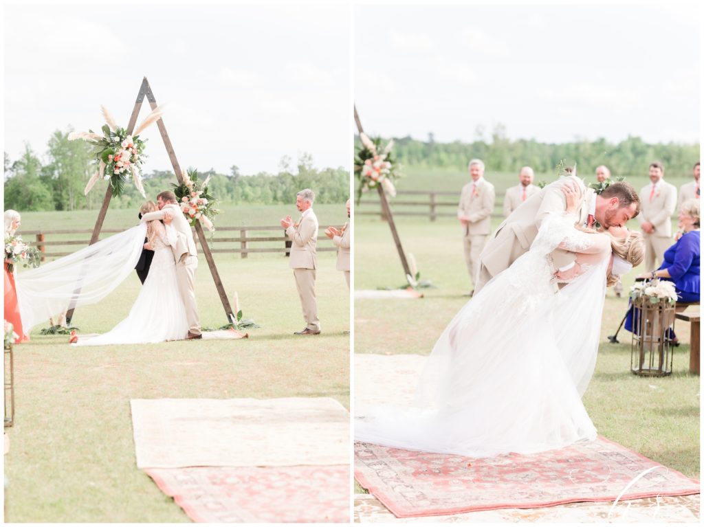 Bride and Groom kissing on wedding day. Elegant Boho wedding ceremony site. 