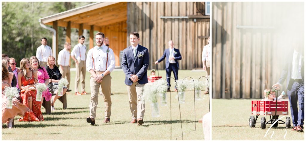 Groom walking down the aisle with his best man on his wedding day. Flower girls and ring bearer being pulled in wagon. 