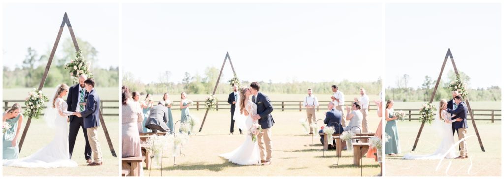 Bride and groom at the blessed barn during ceremony kiss. Boho wedding vows exchanged on beautiful sunny day. 