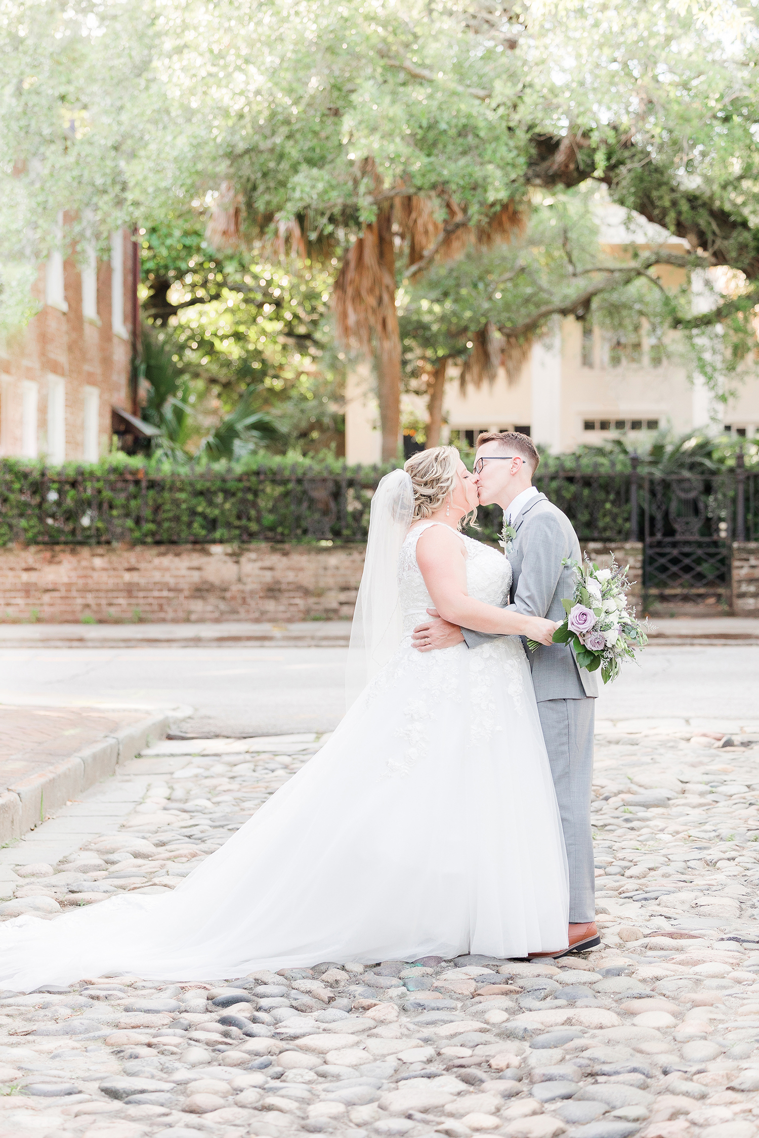 Bride and Groom kissing on cobble stone in Charleston SC