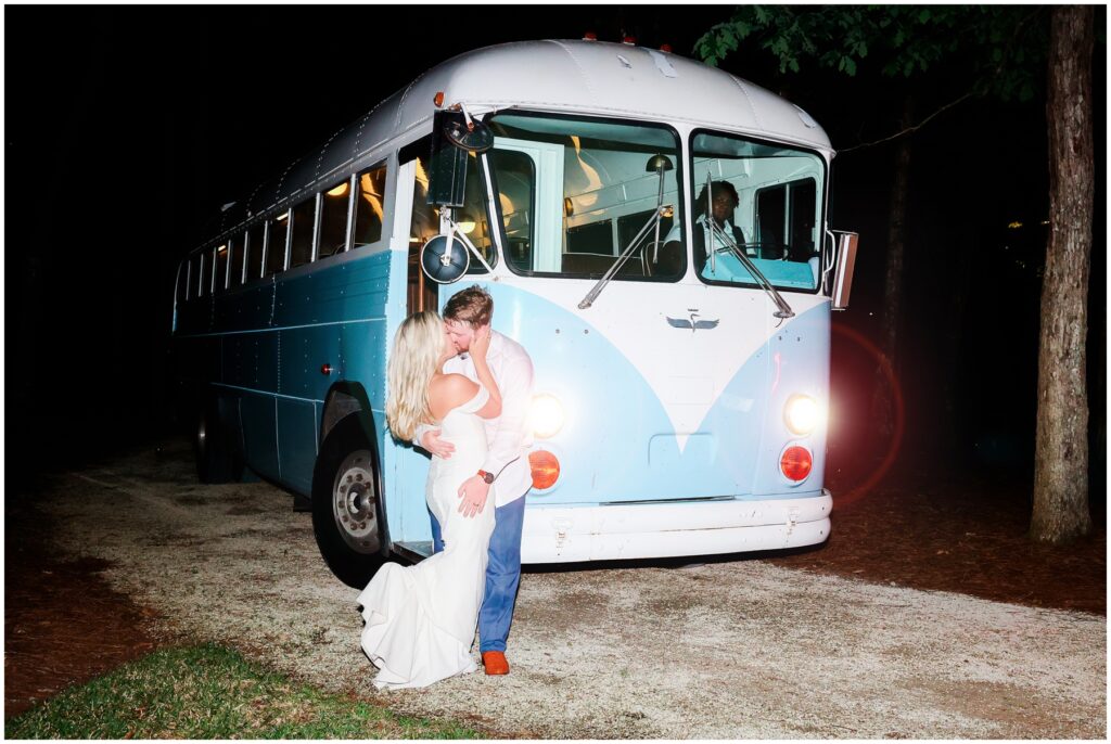 Bride and groom kissing in front of get a way bus on wedding day - blue VW