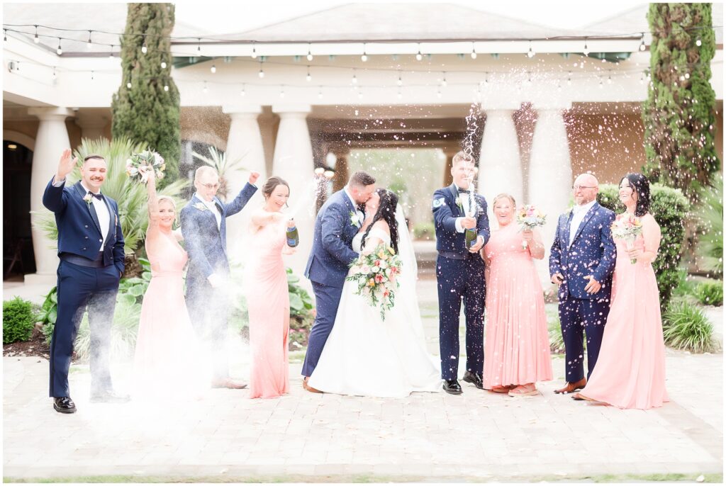 Popping the champaign on wedding day with bridal party 