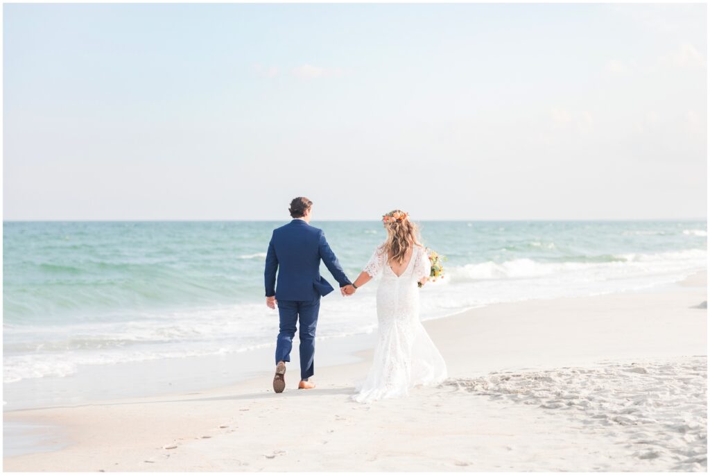 Bride and Groom walking on beach 