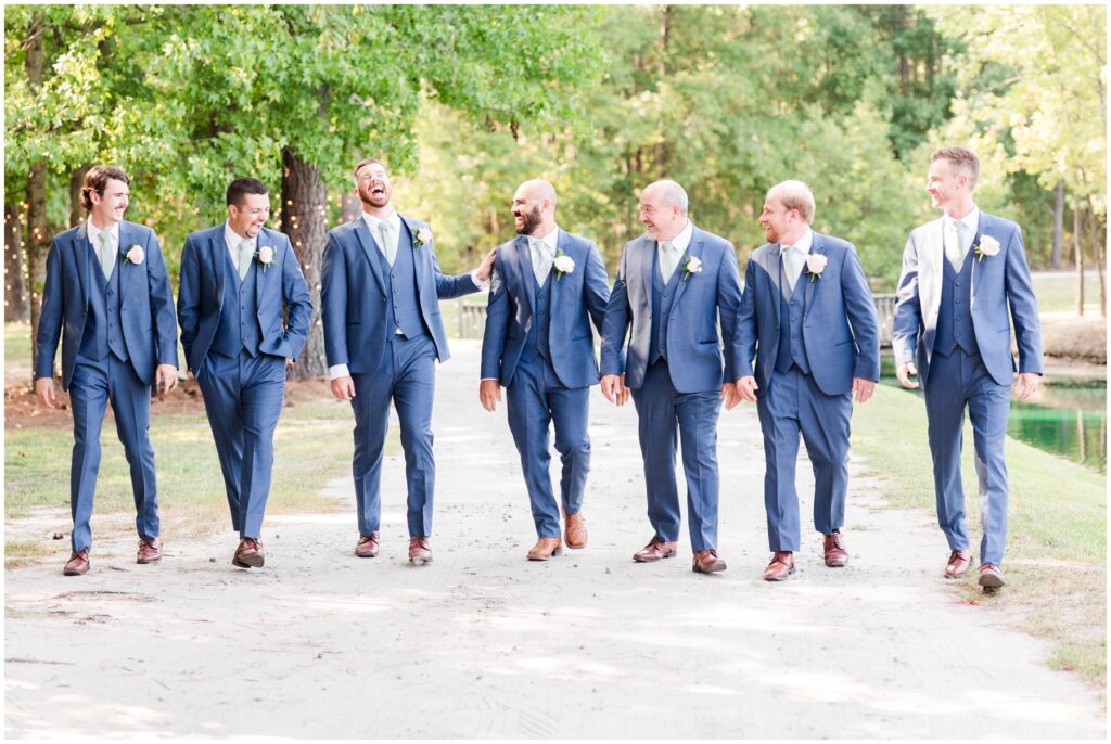 groomsmen and groom walking on property at wedding venue 