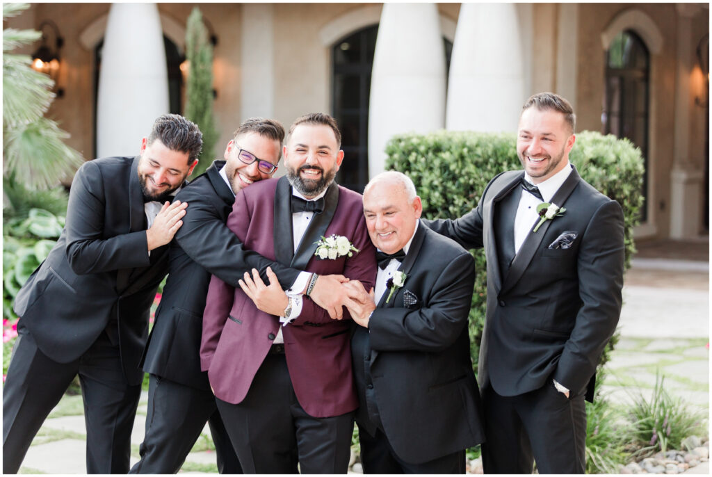 Groomsmen giving the groom a hug after wedding day