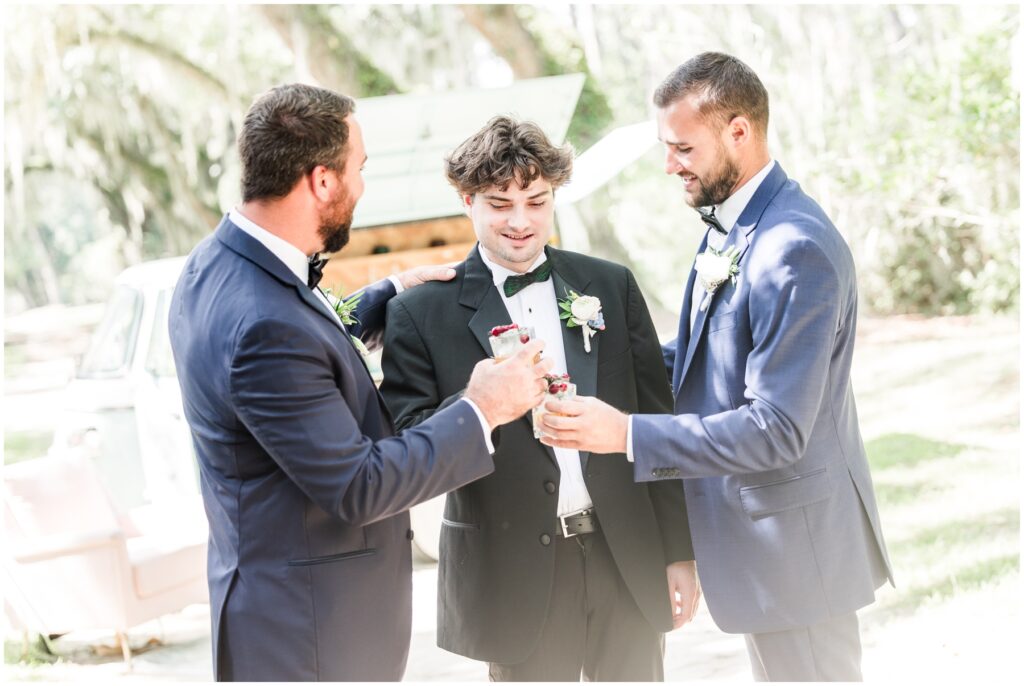 Boys at wedding venue with Spanish moss drinking bourbon 