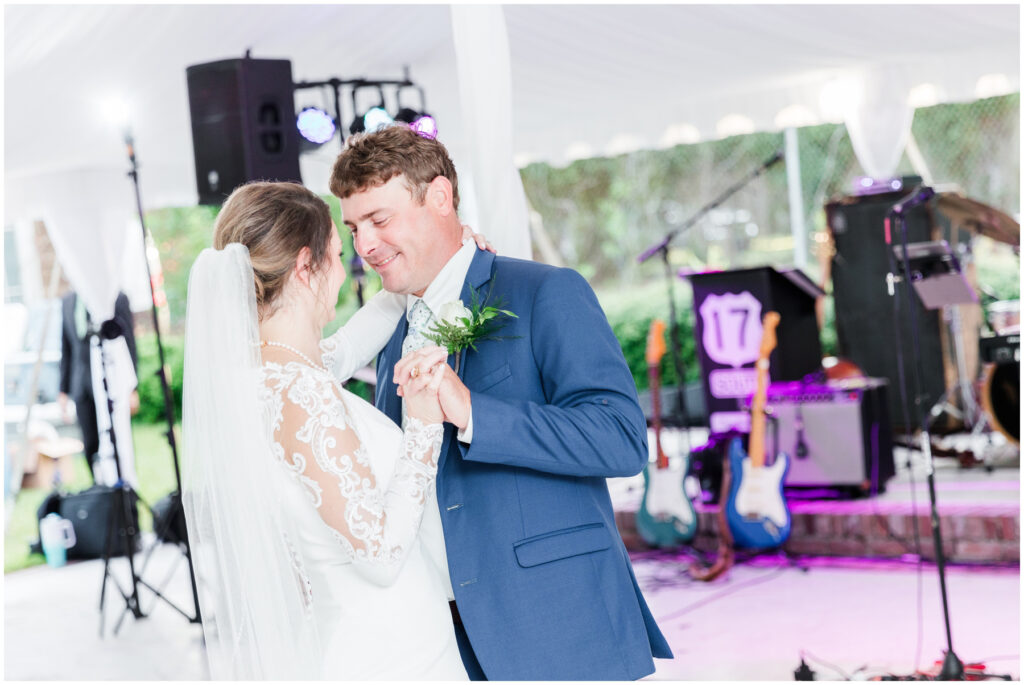First dance on wedding day under white tent with band 
