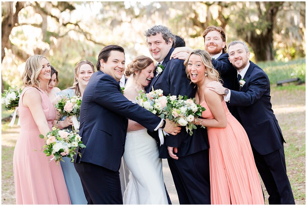 Bridal party hugging each other for photos. 