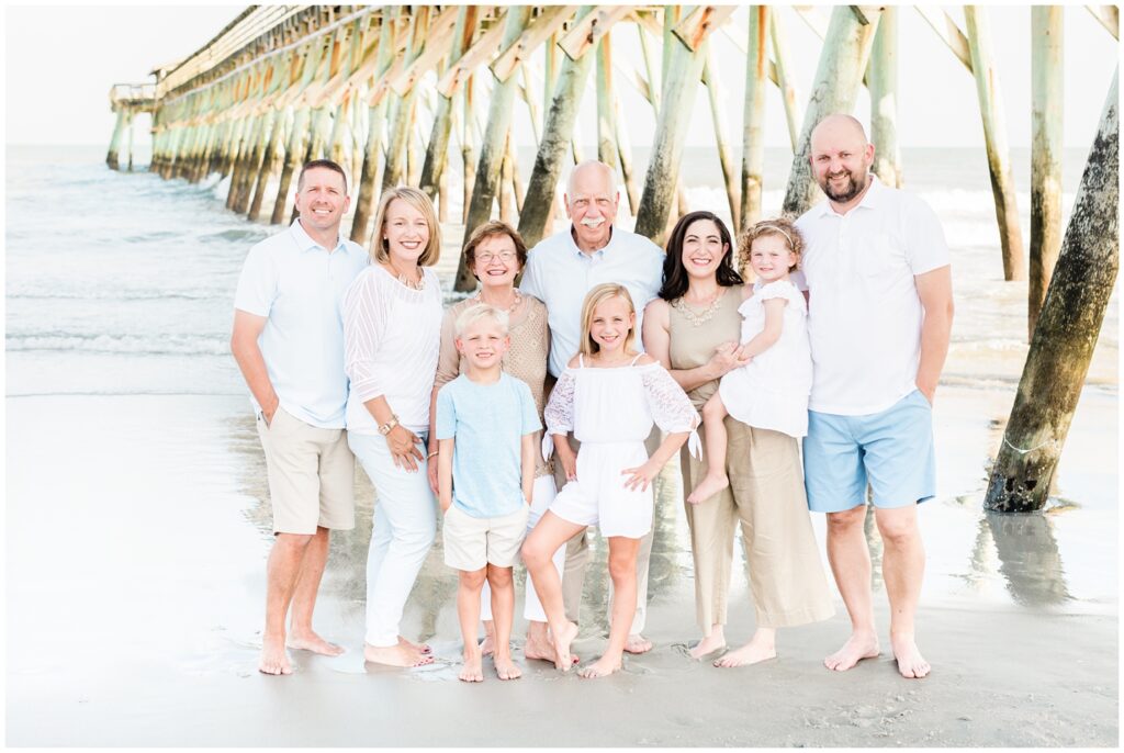 standing by the pier on the beach for photos. 