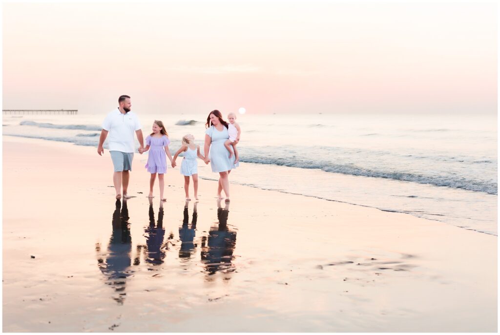 family walking on beach during sunrise family photoshoot