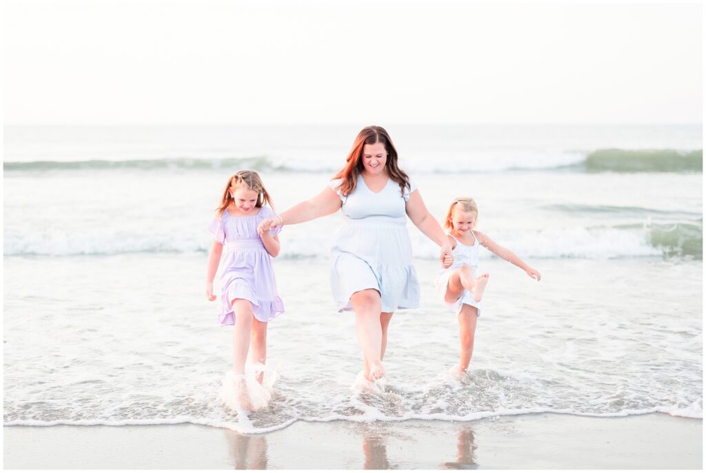 mom and daughters playing in the ocean