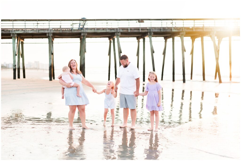 fun family photoshoot walking on the beach