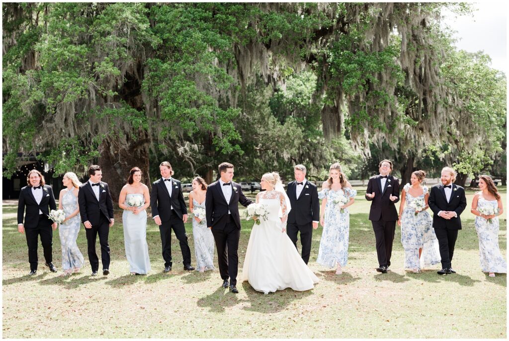  Bride and groom walking through blooming gardens at Middleton Place Charleston wedding venue