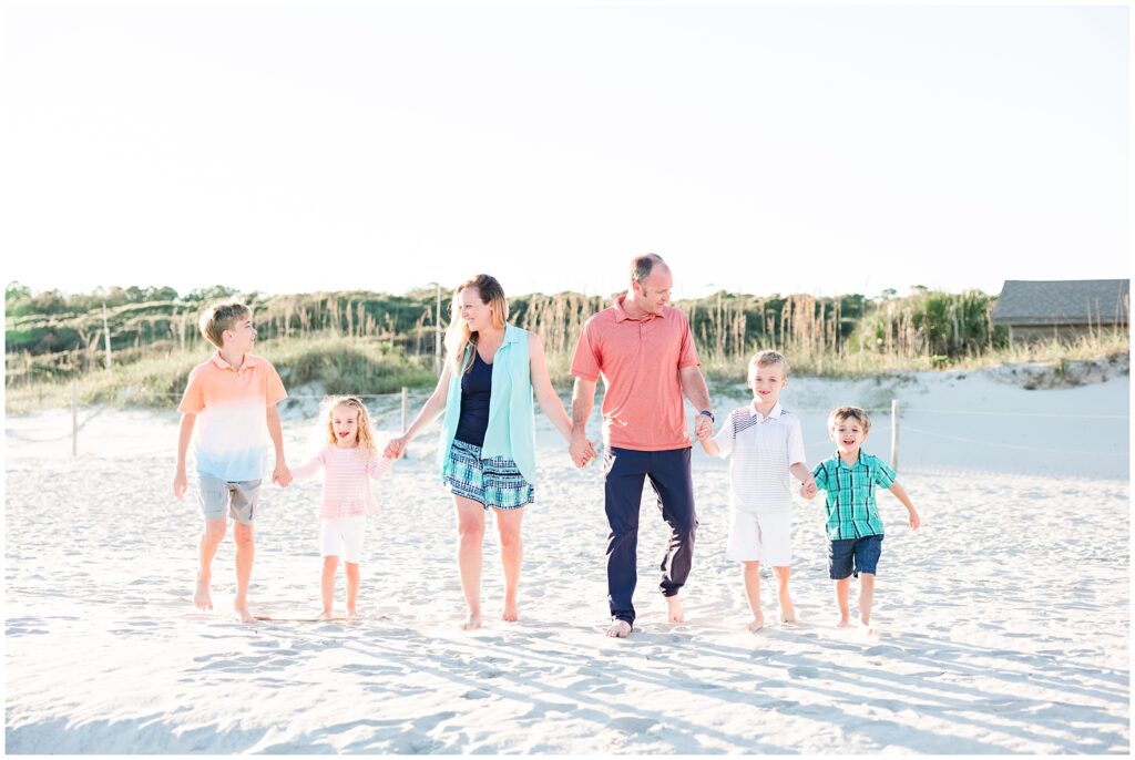 Family of six walking on the beach for photos 